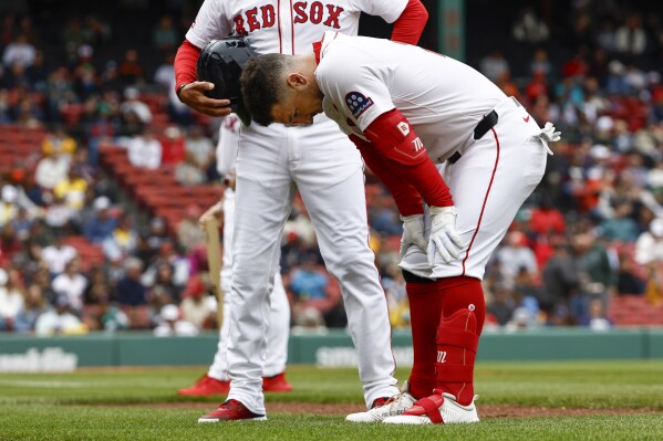 Boston Red Sox's Alex Bregman bends over before leaving the game after injuring himself on a single against the Baltimore Orioles during the fifth inning in the first baseball game of a doubleheader Friday, May 23, 2025, at Fenway Park in Boston. (AP Photo/Winslow Townson)