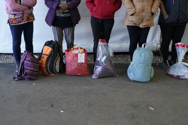 Women wait in a hallway Friday, Dec. 15, 2023, at a Border Patrol station in Ajo, Ariz. (AP Photo/Gregory Bull)