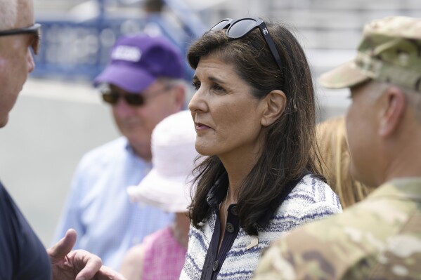 Republican presidential candidate Nikki Haley, center, stands with her husband, Maj. Michael Haley, talking with other military families following a deployment ceremony for his South Carolina National Guard unit on Saturday, June 17, 2023, in Charleston, S.C. Haley's yearlong deployment to Africa will encompass much of the campaign of his wife, former Gov. Nikki Haley, for the 2024 GOP presidential nomination. (AP Photo/Meg Kinnard)