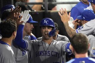 Kansas City Royals' Whit Merrifield celebrate in the dugout his home run off Chicago White Sox starting pitcher Michael Kopech during the sixth inning of a baseball game Monday, Aug. 1, 2022, in Chicago. (AP Photo/Charles Rex Arbogast)