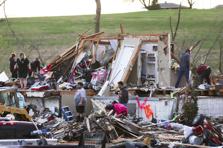 Families sift through the destruction from a tornado, Friday, April 26, 2024, near Omaha, Neb. (Nikos Frazier/Omaha World-Herald via AP)