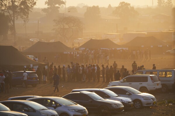 Voters wait in a queue to cast their votes at a polling station in Harare, Wednesday, Aug. 23 2023. Polls opened in Zimbabwe on Wednesday as President Emmerson Mnangagwa seeks a second and final term in a country with a history of violent and disputed votes. (AP Photo/Tsvangirayi Mukwazhi)