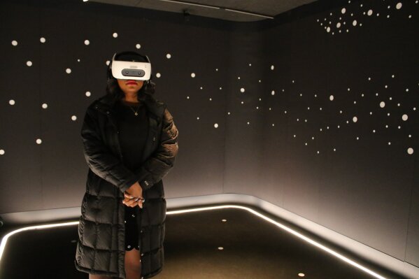 In this Wednesday, Feb. 26, 2020 photo, a visitor experiences "The March" virtual reality exhibit at the DuSable Museum of African American History in Chicago ahead of the project's launch. The exhibit captures the 1963 March on Washington during which Martin Luther King Jr. delivered his famous 'I Have a Dream' speech. (AP Photo/Noreen Nasir)