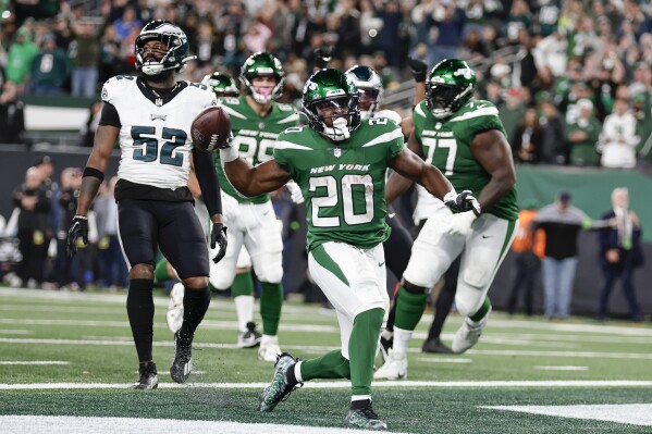 New York Jets' Breece Hall, center, reacts after scoring a touchdown during the second half of an NFL football game against the Philadelphia Eagles, Sunday, Oct. 15, 2023, in East Rutherford, N.J. (AP Photo/Adam Hunger)