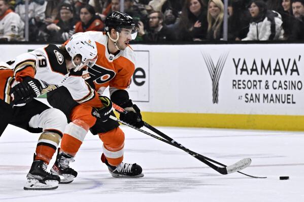 Philadelphia Flyers center Morgan Frost, right, controls the puck under pressure from Anaheim Ducks right wing Troy Terry during the first period of an NHL hockey game in Anaheim, Calif., Monday, Jan. 2, 2023. (AP Photo/Alex Gallardo)