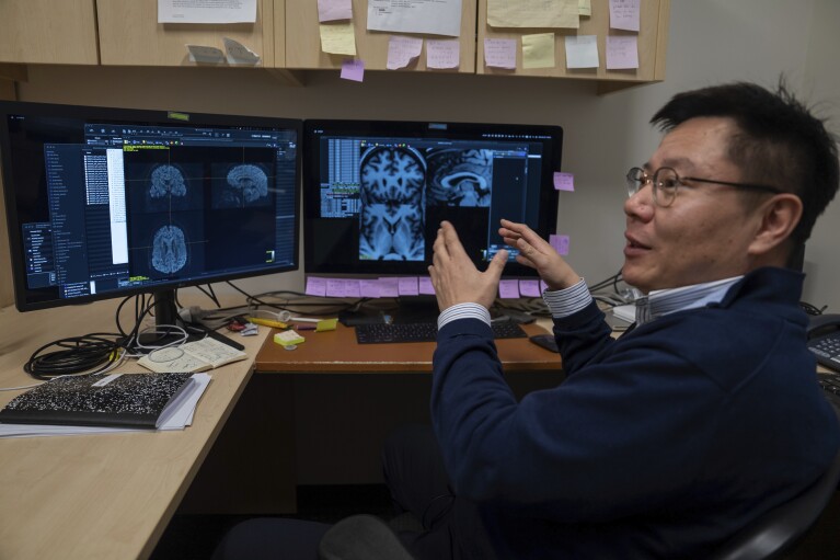 CORRECTS TO KI SUENG CHOI, NOT KI SEUNG CHOI - Neuroimaging expert Ki Sueng Choi explains how he uses brain scans to locate the exact spot in a particular patient where electrodes for deep brain stimulation therapy should be placed, at Mount Sinai West in New York on Dec. 20, 2023. Dr. Helen Mayberg, founding director of The Nash Family Center for Advanced Circuit Therapeutics, says, “Everybody’s brain is a little different, just like people’s eyes are a little further apart or a nose is a little bigger or smaller." (AP Photo/Mary Conlon)