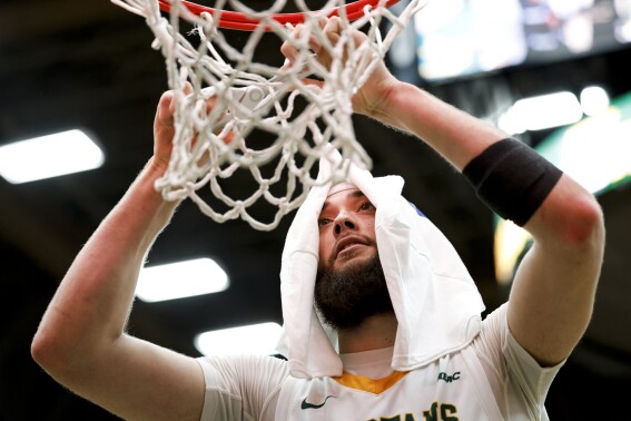 Norfolk State's Tyrel Bladen cuts a piece of net off after the team's win over Purdue Fort Wayne in the CIT championship college basketball game Wednesday, March 27, 2024, in Norfolk, Va. (Billy Schuerman/The Virginian-Pilot via AP)