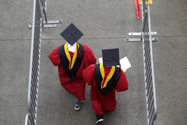 FILE - New graduates walk into the High Point Solutions Stadium before the start of the Rutgers University graduation ceremony in Piscataway Township, N.J., on May 13, 2018. The Supreme Court is about to hear arguments over President Joe Biden’s student debt relief plan. It's a plan that impacts millions of borrowers who could see their loans wiped away or reduced. (AP Photo/Seth Wenig, File)