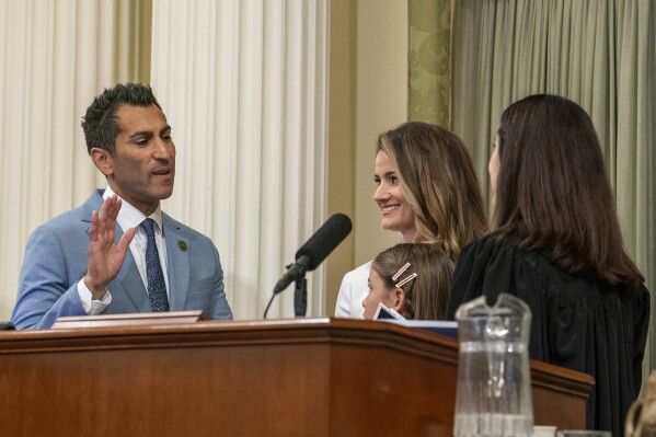 Assemblyman Robert Rivas, D-Hollister, is sworn-in as the 71st Speaker of the California Assembly by California Supreme Court Justice Patricia Guerrero, right, the Capitol in Sacramento, Calif., Friday, June 30, 2023. Rivas is replacing current Assembly Speaker Anthony Rendon, D-Lakewood, who has held the position since 2016. Accompanying Rivas is his wife, Christen, center, and daughter Melina,7, third from left. (AP Photo/Rich Pedroncelli)