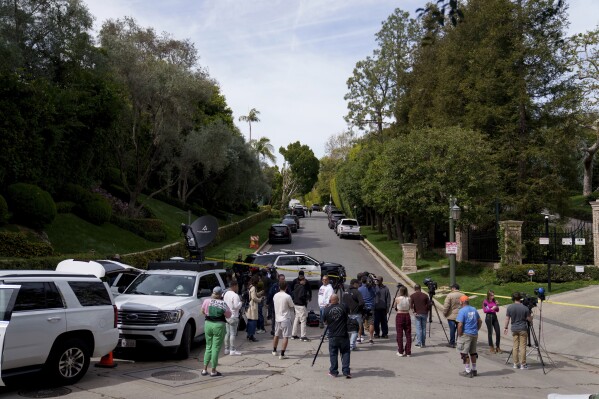 Media gathers as law enforcement blocks a street in front of a property belonging to Sean "Diddy" Combs on Monday, March 25, 2024, in Los Angeles. Two properties belonging to Combs in Los Angeles and Miami were searched Monday by federal Homeland Security Investigations agents and other law enforcement as part of an ongoing sex trafficking investigation by federal authorities in New York, two law enforcement officials told The Associated Press. (AP Photo/Eric Thayer)