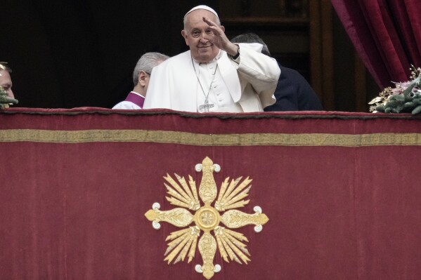 Pope Francis waves before delivering the Urbi et Orbi (Latin for 'to the city and to the world' ) Christmas' day blessing from the main balcony of St. Peter's Basilica at the Vatican, Monday Dec. 25, 2023. (AP Photo/Gregorio Borgia)