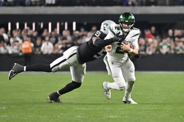 New York Jets quarterback Zach Wilson (2) is tackled by Las Vegas Raiders linebacker Divine Deablo (5) during the second half of an NFL football game Sunday, Nov. 12, 2023, in Las Vegas. (AP Photo/David Becker)