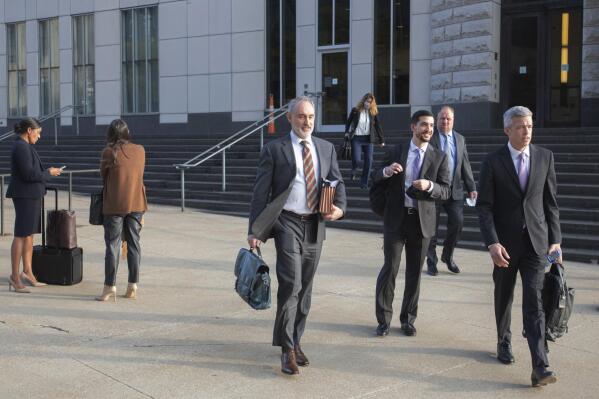 FILE - Attorneys and staff associated with a federal trial of pharmacies, CVS, Walgreens, Giant Eagle and Walmart leave the Carl B. Stokes Federal Courthouse in Cleveland, Monday, Oct. 4, 2021. The pharmacies are being sued by Ohio counties Lake and Trumbull for their part in the opioid crisis. Pittsburgh-based Giant Eagle, one of the four retail pharmacy companies on trial for their alleged roles in fostering an opioid crisis in two Ohio counties announced Friday, Oct. 29, 2021 it had settled lawsuits filed by 10 government entities in the state that have accused the companies of creating a public nuisance. (AP Photo/Phil Long, File)