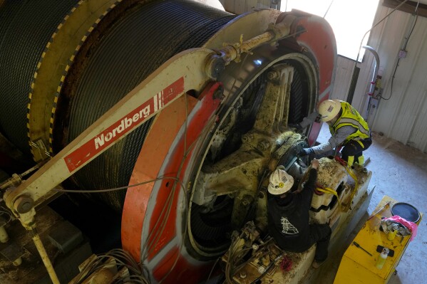 Workers perform routine maintenance on a mining winch at the Energy Fuels Inc. uranium Pinyon Plain Mine Wednesday, Jan. 31, 2024, near Tusayan, Ariz. (AP Photo/Ross D. Franklin)