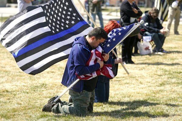 Marius Annandale kneels while praying during a Second Amendment rally at the Utah State Capitol Saturday, March 27, 2021, in Salt Lake City. (AP Photo/Rick Bowmer)