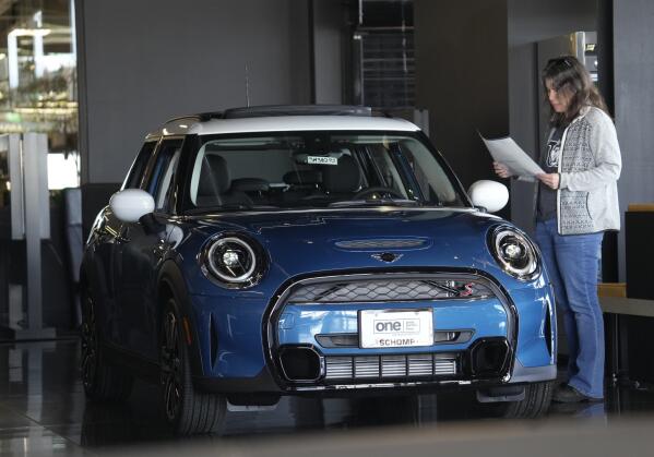 File - A potential buyer looks over an 2023 Cooper S sedan on the floor of a Mini dealership Friday, Feb. 17, 2023, in Highlands Ranch, Colo. On Friday, the Commerce Department issues its March report on consumer spending. (AP Photo/David Zalubowski, File)