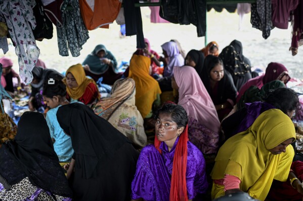 Ethnic Rohingya women take shelter under a tent near the beach where they landed on Dec. 10 in Pidi, Aceh province, Indonesia, Saturday, Dec. 16, 2023.  (AP Photo/Reza Saifullah)