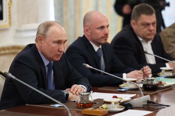 Russian President Vladimir Putin, left, speaks during a meeting with Russian war correspondents who cover a special military operation at the Kremlin in Moscow, Russia, Tuesday, June 13, 2023. (Gavriil Grigorov, Sputnik, Kremlin Pool Photo via AP)