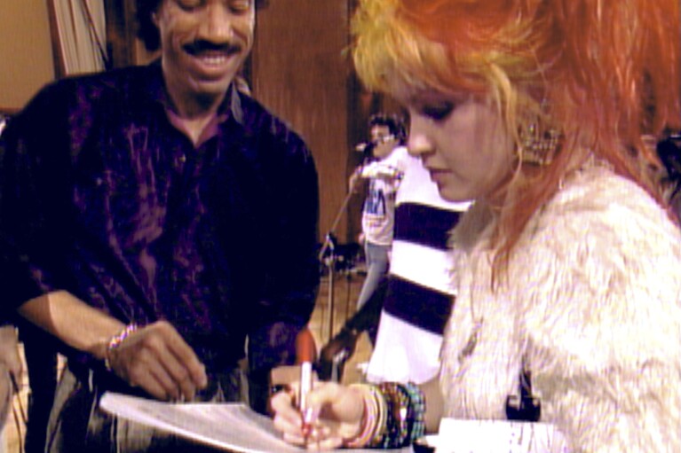 This image released by Netflix shows Lionel Richie, left, and Cyndi Lauper in a scene from "The Greatest Night in Pop." (Netflix via AP)