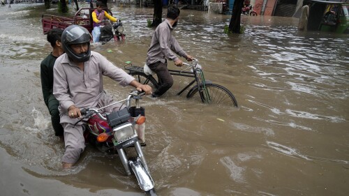 Motorcyclists drive through a flooded road caused by heavy rainfall, in Lahore, Pakistan, Monday, June 26, 2023. (AP Photo/K.M. Chaudary)