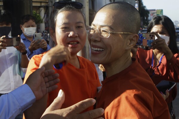 FILE - Theary Seng, right, a Cambodian-American lawyer, dressed in a prison-style orange outfit, greets her supporters as she arrived at Phnom Penh Municipal Court in Phnom Penh, Cambodia, on Jan. 4, 2022. The United Nations Working Group on Arbitrary Detention said in a judgement late Wednesday, July 12, 2023, that while attorney Theary Seng had been convicted of conspiracy to commit treason and other charges last year, her only crime was “making two posts on Facebook critical of Hun Sen,” Cambodia's autocratic prime minister. (AP Photo/Heng Sinith, File)