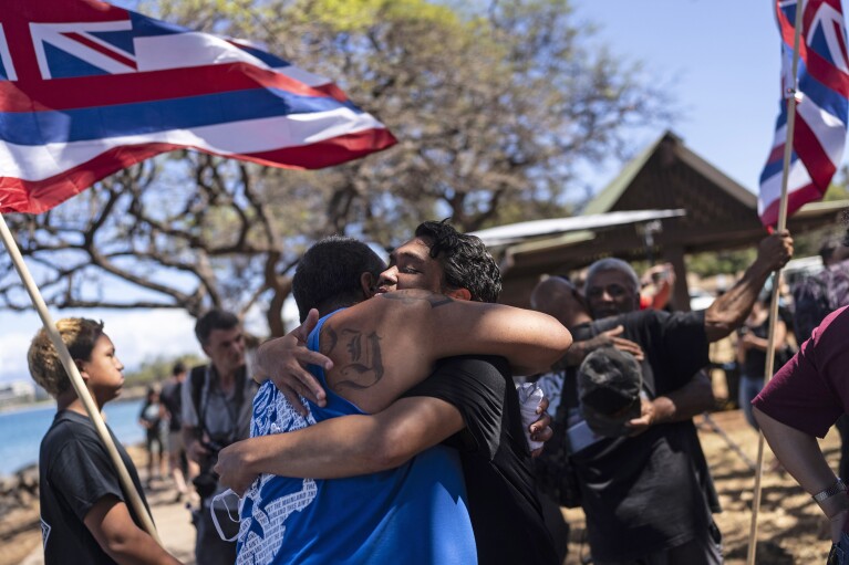 FILE - Lahaina, Hawaii, residents, who are affected by a deadly wildfire that devastated the community, hug one another after a news conference in Lahaina, Hawaii, Friday, Aug. 18, 2023. (APPhoto/Jae C. Hong, File)