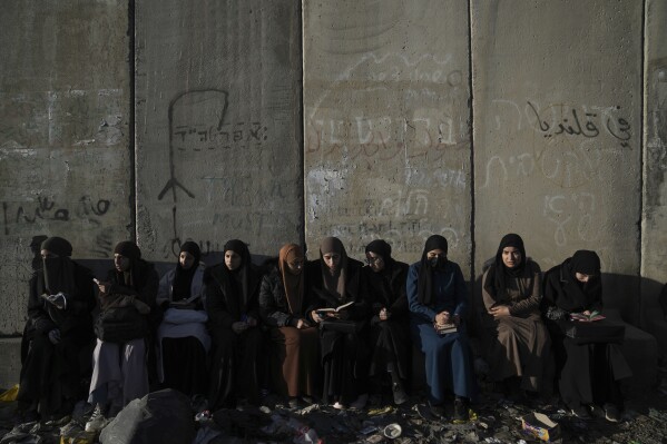 Palestinian women wait to cross the Israeli military Qalandia checkpoint near the West Bank city of Ramallah to Jerusalem, to participate in Friday prayers at the Al-Aqsa Mosque compound during the Muslim holy month of Ramadan on Friday, March 15, 2024. (AP Photo/Nasser Nasser)