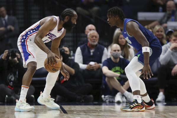 Philadelphia 76ers guard James Harden, left, is defended by Minnesota Timberwolves forward Anthony Edwards during the first half of an NBA basketball game Friday, Feb. 25, 2022, in Minneapolis. (AP Photo/Stacy Bengs)