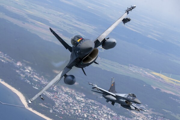 FILE - A Romanian Air Force F- 16s military fighter jet, left, and a Portuguese Air Force F- 16s military fighter jets participating in NATO's Baltic Air Policing Mission operate over the Baltic Sea, Lithuanian airspace, on May 22, 2023. The United States has given its approval for the Netherlands to deliver F-16s to Ukraine, the Dutch defense minister said Friday, Aug. 18, 2023 in a major gain for Kyiv even though the fighter jets won’t have an immediate impact on the almost 18-month war. (AP Photo/Mindaugas Kulbis, File)