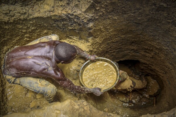 FILE- Miners extract mud they hope contains gold at a gold mining site at which adults and youth work in the village of Mawero, on the outskirts of Busia town, in eastern Uganda on Oct. 18, 2021. Billons of dollars worth of gold is smuggled out of Africa each year, according to a report published Thursday, of which most ends up in the United Arab Emirates where it is refined and sold on to the rest of the world. Over $30 billion worth of gold, or more than 435 tonnes, was smuggled out of Africa in 2022, according to the report published by Swissaid, an aid and development group based in Switzerland. (AP Photo/Nicholas Bamulanzeki, File)