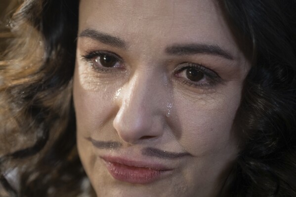 Actress Ruslana Ostapko, wearing a painted moustache, cries as the talks about her male colleagues who joined the Ukrainian army and were killed in Russia-Ukraine war, in the Chernihiv Regional Youth Theater in Chernihiv, Ukraine, Sunday, Feb. 16, 2025. (AP Photo/Efrem Lukatsky)