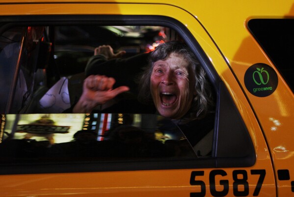 FILE - A woman reacts while sitting in a taxi as different television networks call the presidential race for Barack Obama, Nov. 4, 2008, in New York. (AP Photo/Anja Niedringhaus, File)