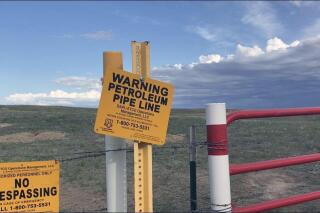 FILE - In this May 20, 2021, file photo, signs marking the Dakota Access Pipeline are posted north of Cannonball, N.D. and the Standing Rock Reservation. Texas-based Energy Transfer, the company that operates the Dakota Access oil pipeline, is asking the U.S. Supreme Court to reverse an appellate ruling ordering additional environmental review, saying it puts the line at risk of being shut down. (AP Photo/Matthew Brown, File)