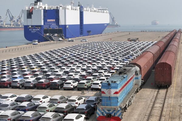 FILE - A freight train carrying cars to be exported arrives at a dock for ro-ro shipping in Yantai in eastern China's Shandong province Sunday, March 3, 2024. China’s exports contracted in March after growing in the first two months of the year, underscoring the uneven nature of the country's recovery from the pandemic. (Chinatopix via AP, File)