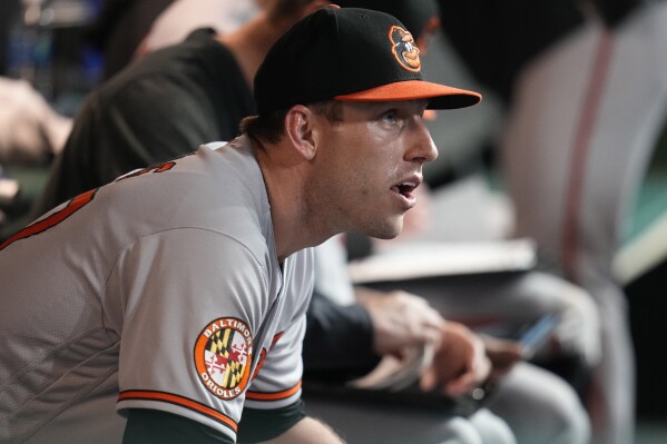 Baltimore Orioles starting pitcher John Means sits in the dugout after being taken out of the game in the eighth inning of a baseball game against the Cleveland Guardians, Saturday, Sept. 23, 2023, in Cleveland. (AP Photo/Sue Ogrocki)
