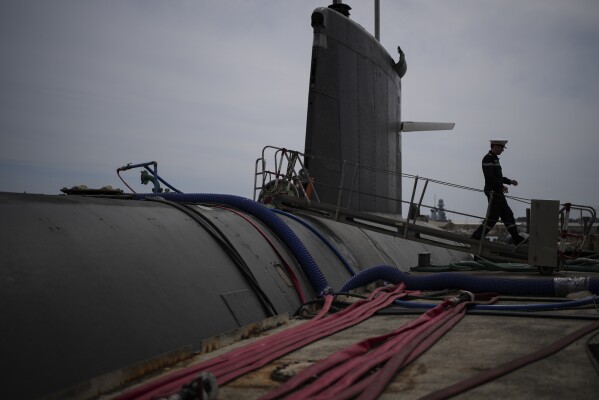 A sailor disembarks a French Rubis-class submarine at the Toulon naval base in southern France, Monday, April 15, 2024. The nuclear powered submarine will be guarding France's Charles de Gaulle aircraft carrier during training exercises dubbed Neptune Strike in the Mediterranean with the 32-nation NATO military alliance. (AP Photo/Daniel Cole)