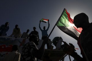 FILE - In this Nov. 19, 2019 file photo, people gather as they celebrate first anniversary of mass protests that led to the ouster of former president and longtime autocrat Omar al-Bashir. in Khartoum, Sudan. On Thursday, June 25, 2020, the United States, Germany and France have pledged hundreds of millions in aid to Sudan. The funds are intended to help the struggling African nation a year after pro-democracy protesters forced the removal of its long-time autocratic ruler, Omar al-Bashir.(AP Photo, File)