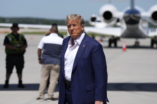 Republican presidential candidate former President Donald Trump walks to his vehicle after arriving at the Des Moines International Airport before his visit to the Iowa State Fair, Saturday, Aug. 12, 2023, in Des Moines, Iowa. (AP Photo/Charlie Neibergall)