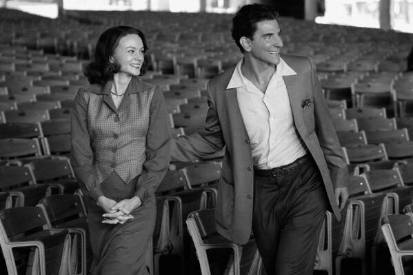 This image released by Netflix shows Carey Mulligan as Felicia Montealegre, left, and Bradley Cooper as Leonard Bernstein in a scene from "Maestro." (Jason McDonald/Netflix via AP)