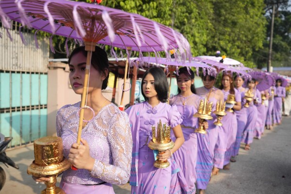 People carrying Buddhist religious stuffs walk during a processional parade as part of a celebration of a novitiation or “Shinbyu,” ceremony, Saturday, March 15, 2025, at Hlegu township, outside of Yangon, Myanmar. (AP Photo/Thein Zaw)