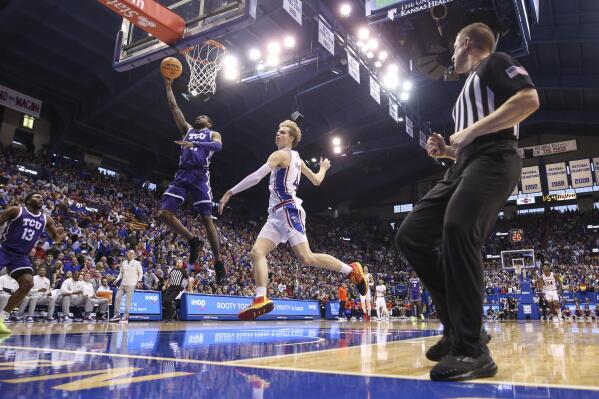 TCU guard Rondel Walker (11) gets inside for a bucket past Kansas guard Gradey Dick (4) during the second half of an NCAA college basketball game on Saturday, Jan. 21, 2023, at Allen Fieldhouse in Lawrence, Kan. TCU defeated Kansas, 83-60. (AP Photo/Nick Krug)