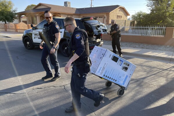 FILE - In this image provided by the Surprise, Ariz., Police Department, Surprise Police officers deliver an air conditioner purchased for two elderly sisters Friday, July 14, 2023, in Surprise, Ariz. Just outside Phoenix five years ago, the death of an older woman brought attention to the dangers of the heat to people who are energy insecure. Stephanie Pullman, then 72, died on a sweltering day in a retirement community after her electricity was cut off because of a $51 debt. (Surprise Police Department via AP, File)