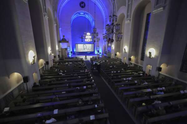 People watch an AI-created service at St. Paul's Lutheran church in Helsinki, Finland, Tuesday, March 4, 2025.