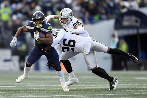 Seattle Seahawks running back Kenneth Walker III (9) runs past Las Vegas Raiders cornerback Rock Ya-Sin (26) and defensive end Maxx Crosby (98) during the first half of an NFL football game Sunday, Nov. 27, 2022, in Seattle. (AP Photo/Caean Couto)
