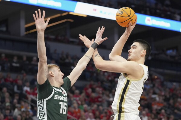 Purdue center Zach Edey, right, shoots over Michigan State center Carson Cooper (15) during the first half of an NCAA college basketball game in the quarterfinal of the Big Ten Conference tournament, Friday, March 15, 2024, in Minneapolis. (AP Photo/Abbie Parr)