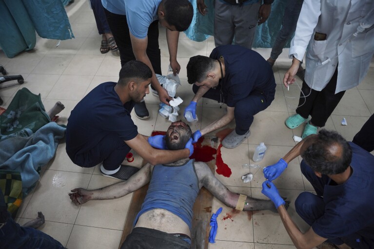 Palestinian paramedics treat a man injured in the Israeli bombing of the Gaza Strip at Al-Aqsa Hospital in Deir al-Balah, Gaza Strip, on Saturday, May 11, 2024. (AP Photo/Saher Alghorra)