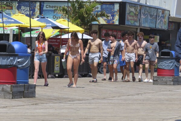 A group of young people walk peacefully along the boardwalk in Seaside Heights, N.J., Friday, May 31, 2024. On Friday, New Jersey Attorney General Matt Platkin blamed the city of Wildwood, N.J., for not assigning enough police officers to patrol its boardwalk over the Memorial Day weekend when crowds of rowdy teens and young adults overwhelmed the city's capability to respond to disturbances, forcing the boardwalk to be shut down overnight on Sunday, May 26. (AP Photo/Wayne Parry)
