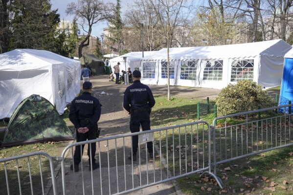 Police officers guard students and former paramilitary fighters loyal to President Aleksandar Vucic are camping outside the presidency building fueling fears of violent incidents during a major anti-corruption rally this weekend in Belgrade, Serbia, Thursday, March 13, 2025. (AP Photo/Darko Vojinovic)