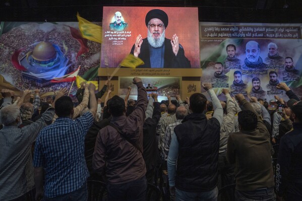 Hezbollah leader Sayyed Hassan Nasrallah speaks in a televised address via a video link during a ceremony to commemorate the death of the Iranian Revolutionary Guard Gen. Mohammad Reza Zahedi and six officers, who were killed by an Israeli airstrike that demolished Iran's consulate in Syria last Monday, in the southern suburbs of Beirut, Lebanon, Monday, April 8, 2024. Nasrallah paid tribute to Zahedi, who spent 12 years of his career as a top general at the Iranian Revolutionary Guards elite Quds Force with Hezbollah. The Hezbollah leader said he played a key role in strengthening and empowering the group which fought several wars with Israel, and has become Iran's key proxy in the region. (AP Photo/Hassan Ammar)