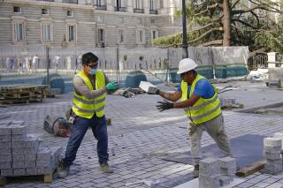 FILE - Two man work at a construction site during a heatwave in Madrid, Spain, Friday, Aug. 13, 2021. Spain says it plans to ban outdoor work during periods of extreme heat. Second Deputy Prime Minister Yolanda Díaz told reporters Wednesday, May 10, 2023 that the government will modify legislation covering occupational risks to prohibit outdoor work when the state weather agency, AEMET, issues red or orange alerts. (AP Photo/Andrea Comas, File)